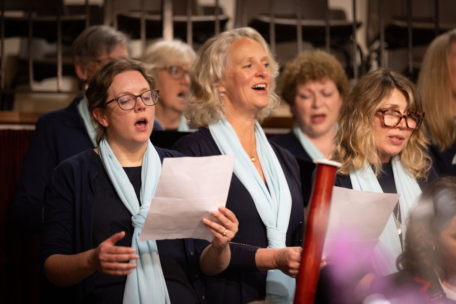 Choir members in concert dress singing from their music