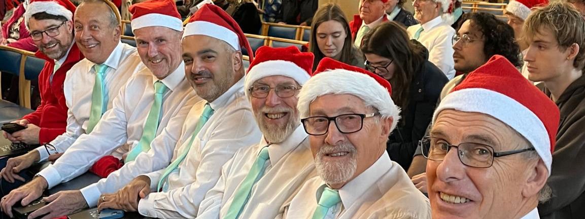 Choir members in Christmas hats at a festive concert