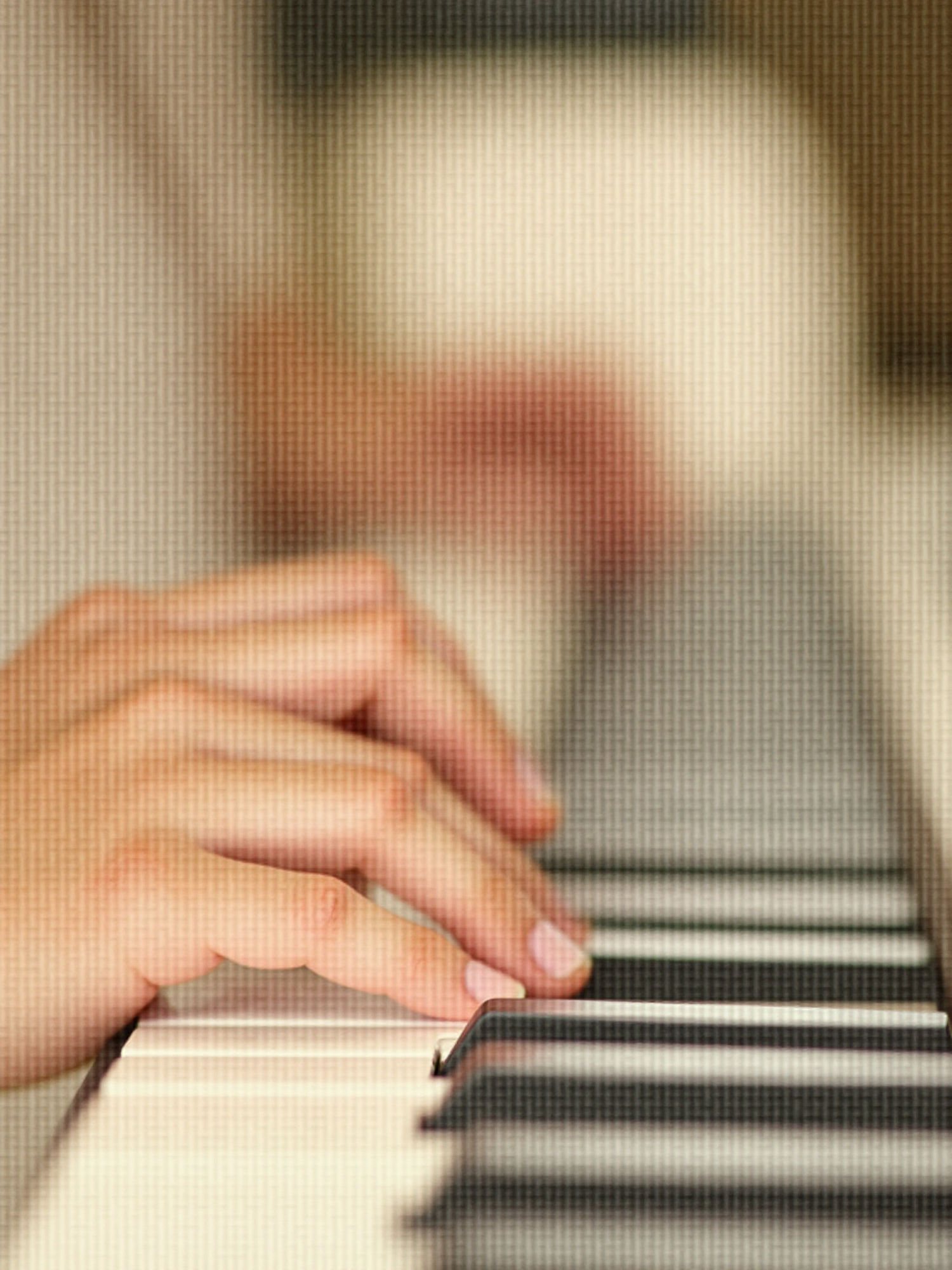 Close-up of hands playing a piano keyboard
