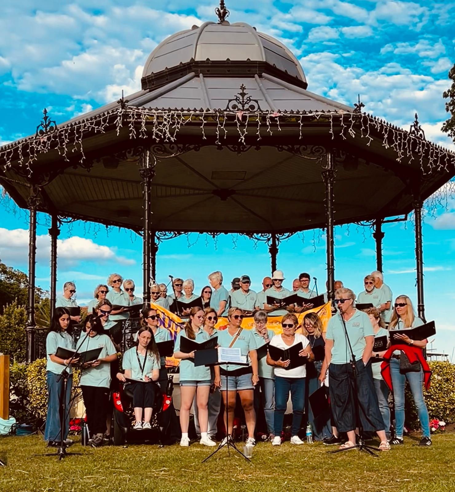 The Choir Engine gathered at a seaside bandstand