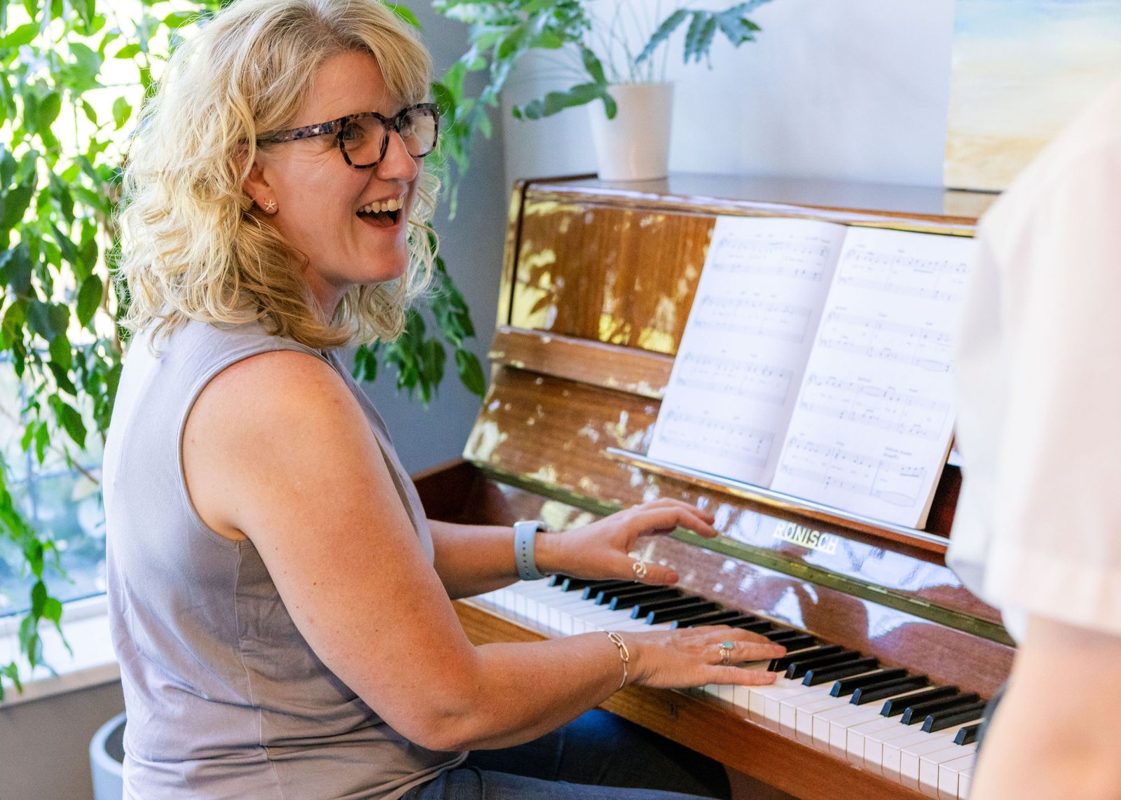Caroline laughing at the piano during a lesson